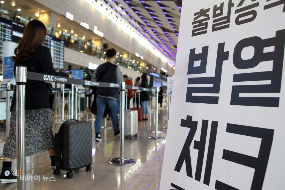 발열검사를 받고 탑승장으로 향하는 여행객들.